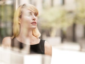 Woman in black dress peering into the distance