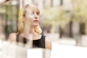 Woman in black dress peering into the distance